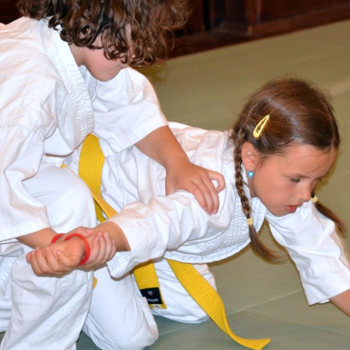 Alsós iskolás gyerekek aikido technikákat gyakorolnak oktatói felügyelettel Esztergomban