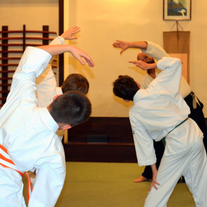 Felsős iskolás gyerekek bemelegítő gyakorlatokat végeznek aikido edzésen a Tada Ima Aikido Akadémián