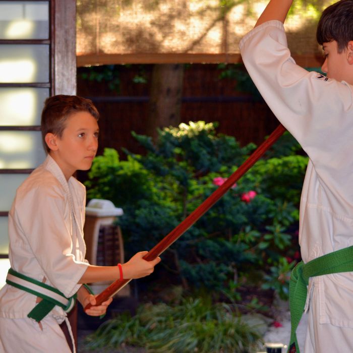Felsős iskolás aikidós gyerek fa fegyverrel gyakorol a Tada Ima Aikido Akadémián