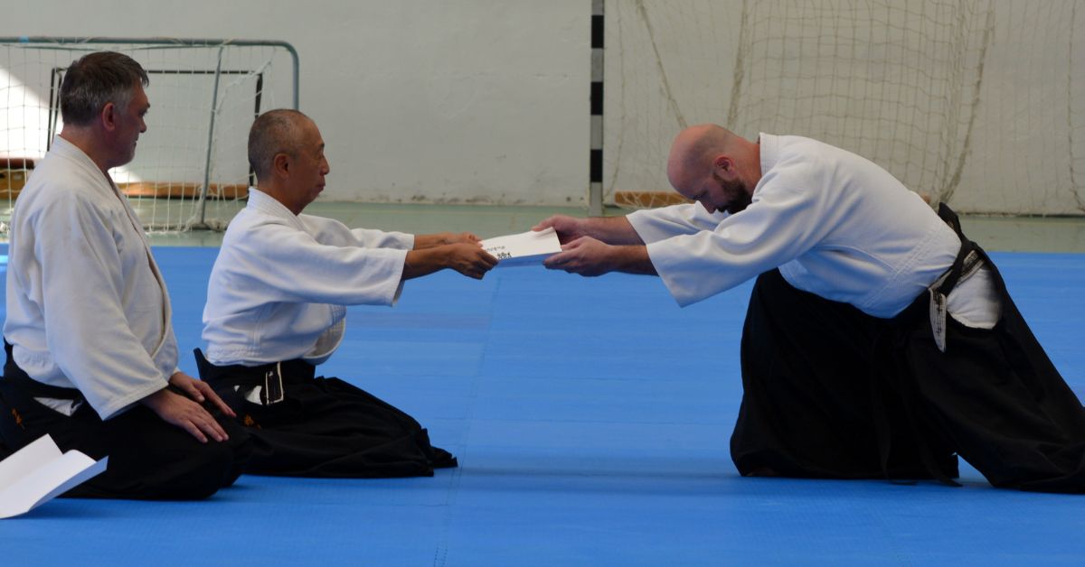 Aikido vizsga utáni oklevélátadás a tatamin, meghajlással
