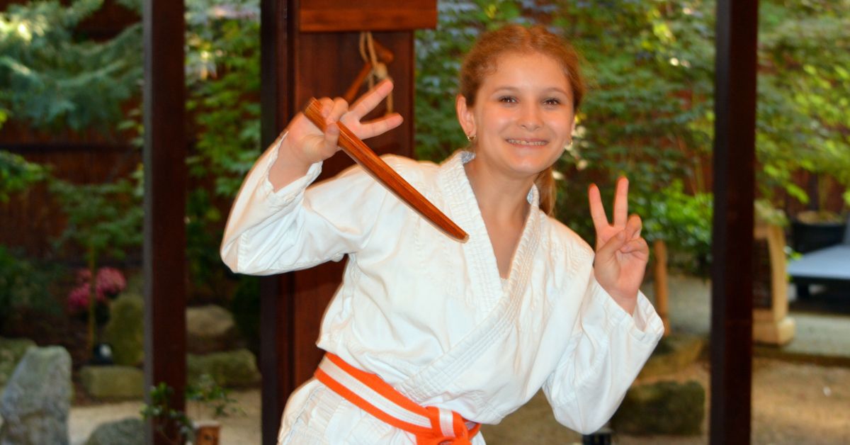 Mosolygó felsős aikidós lány edzőruhában a Tada Ima Aikido Dojo nyílt edzéséhez kapcsolódó képen