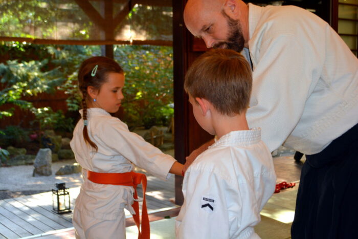 Dr. Havasi Tamás vezető oktató két gyermek aikidogyakorlását segíti az esztergomi Tada Ima Aikido Dojóban.